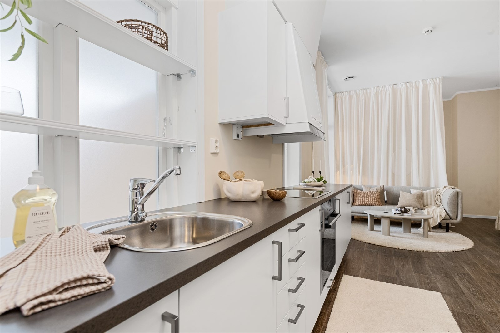 Kjøkkenet har en moderne innredning med slette, malte fronter og laminert benkeplate med nedfelt stålvask. Galleribilde