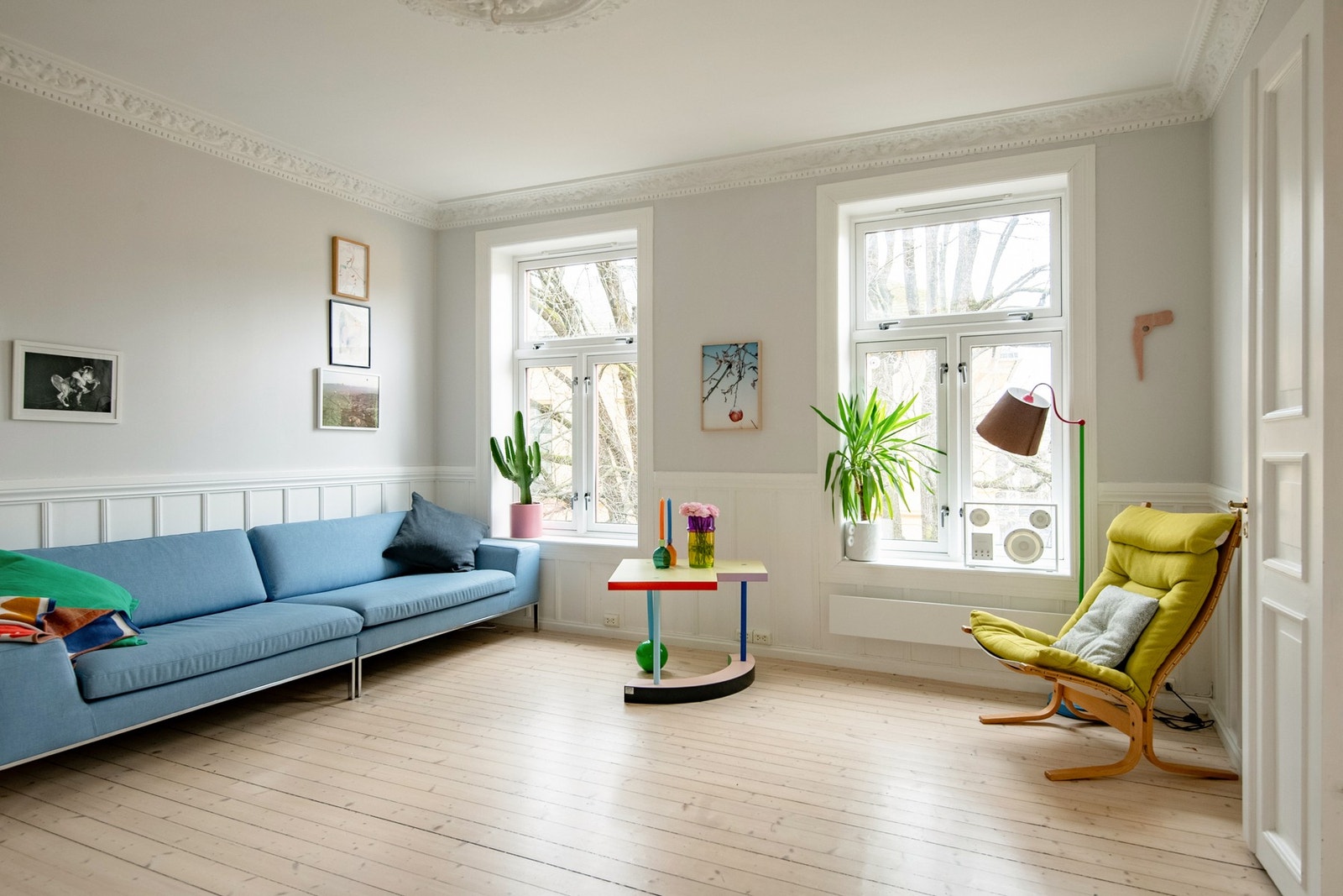 Luftig og lys stue med flotte bygårdstrekk. Her får du dype karmer, store vinduer, originalt tregulv og stukkatur Galleribilde