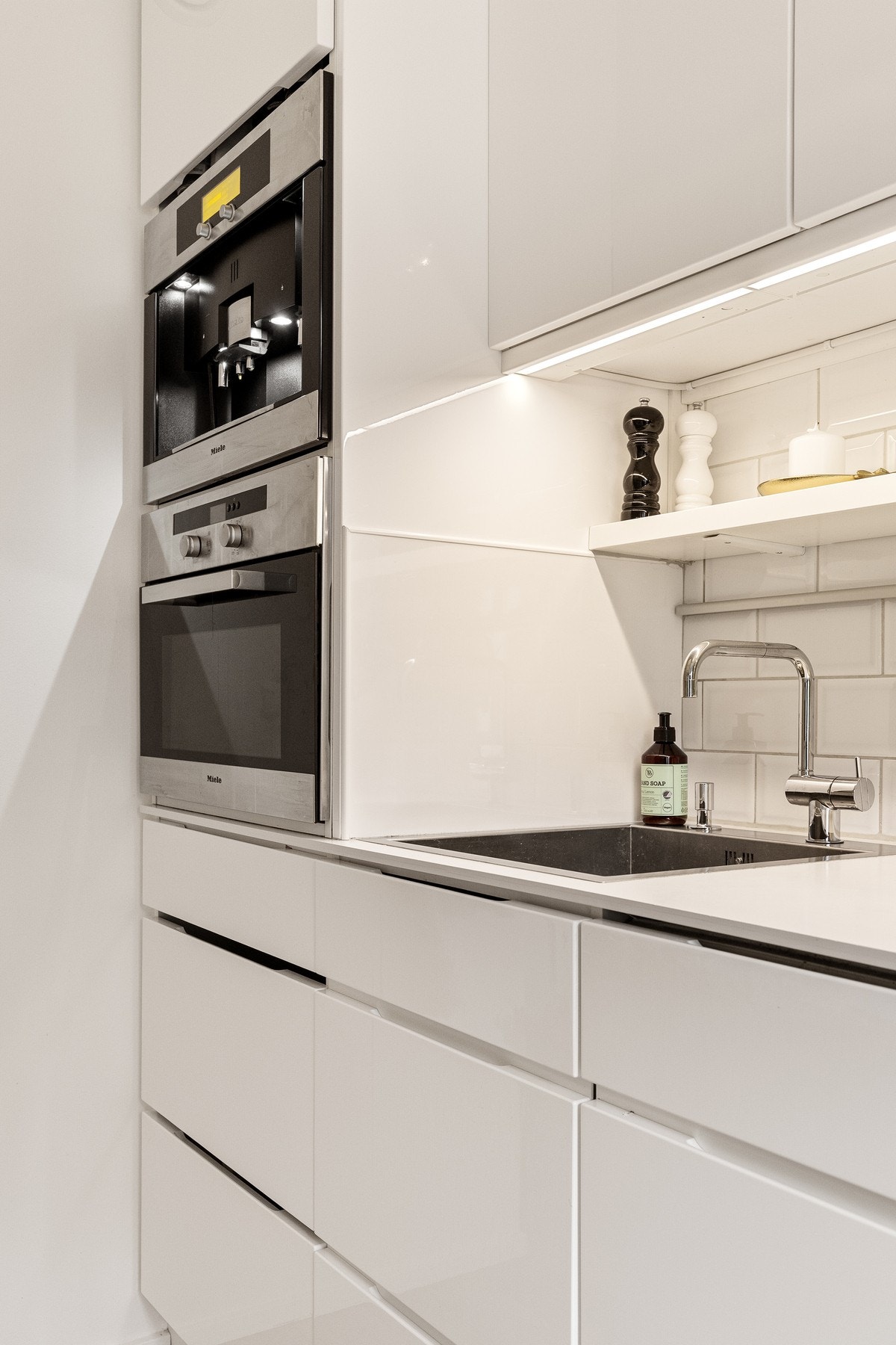 Benkeplaten er utført i kompaktlaminat med nedfelt vask og flislagt vegg over benk. Galleribilde