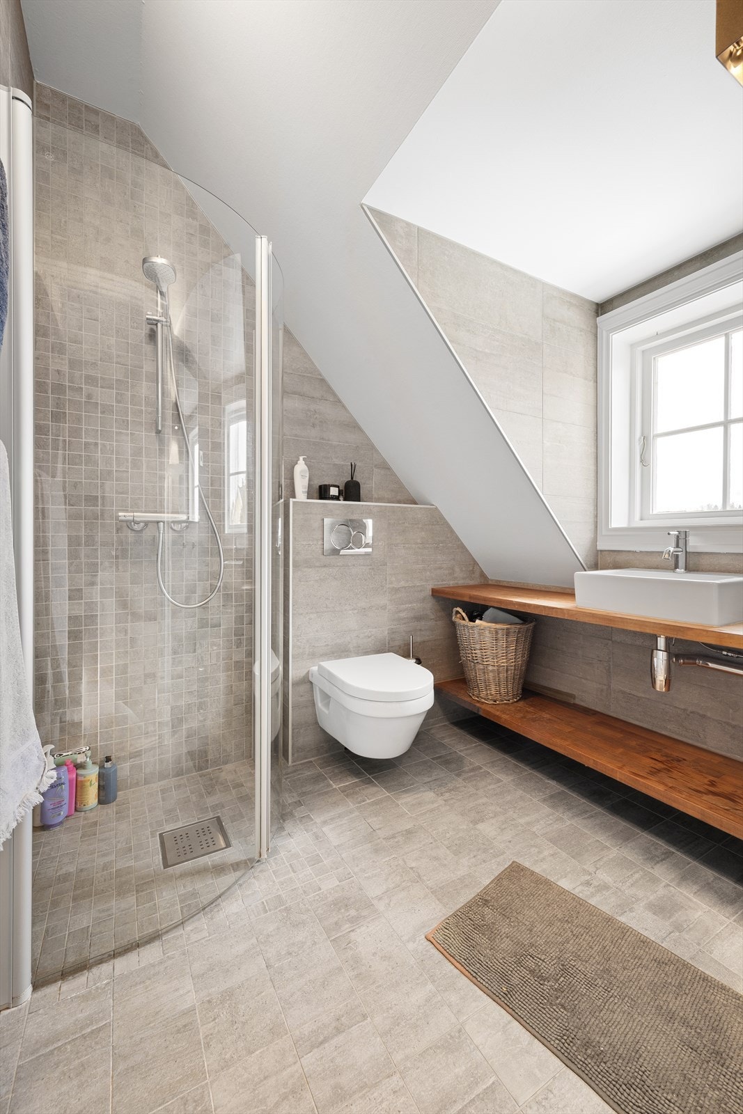 Det andre badet har også flislagt gulv med varmekabler, dusjhjørne og veggmontert toalett. Galleribilde