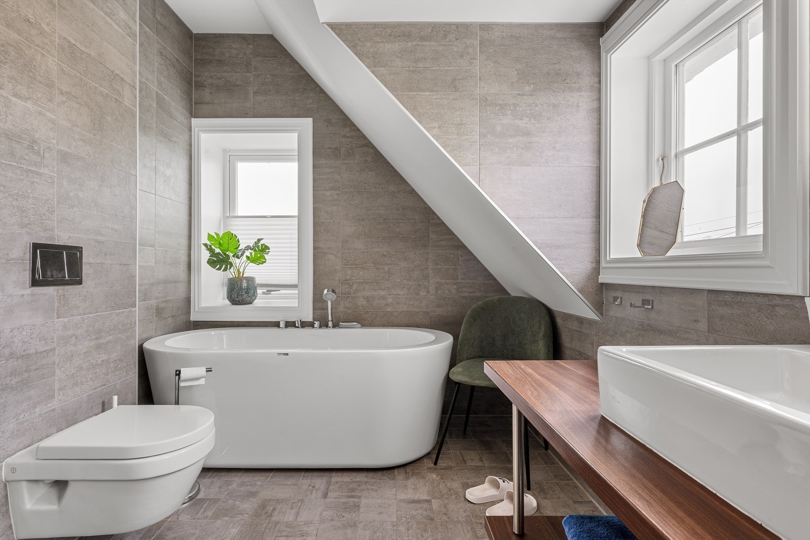 I tillegg til dusj har badet et badekar og veggmontert toalett. Himlingen har innfelte downlights. Galleribilde