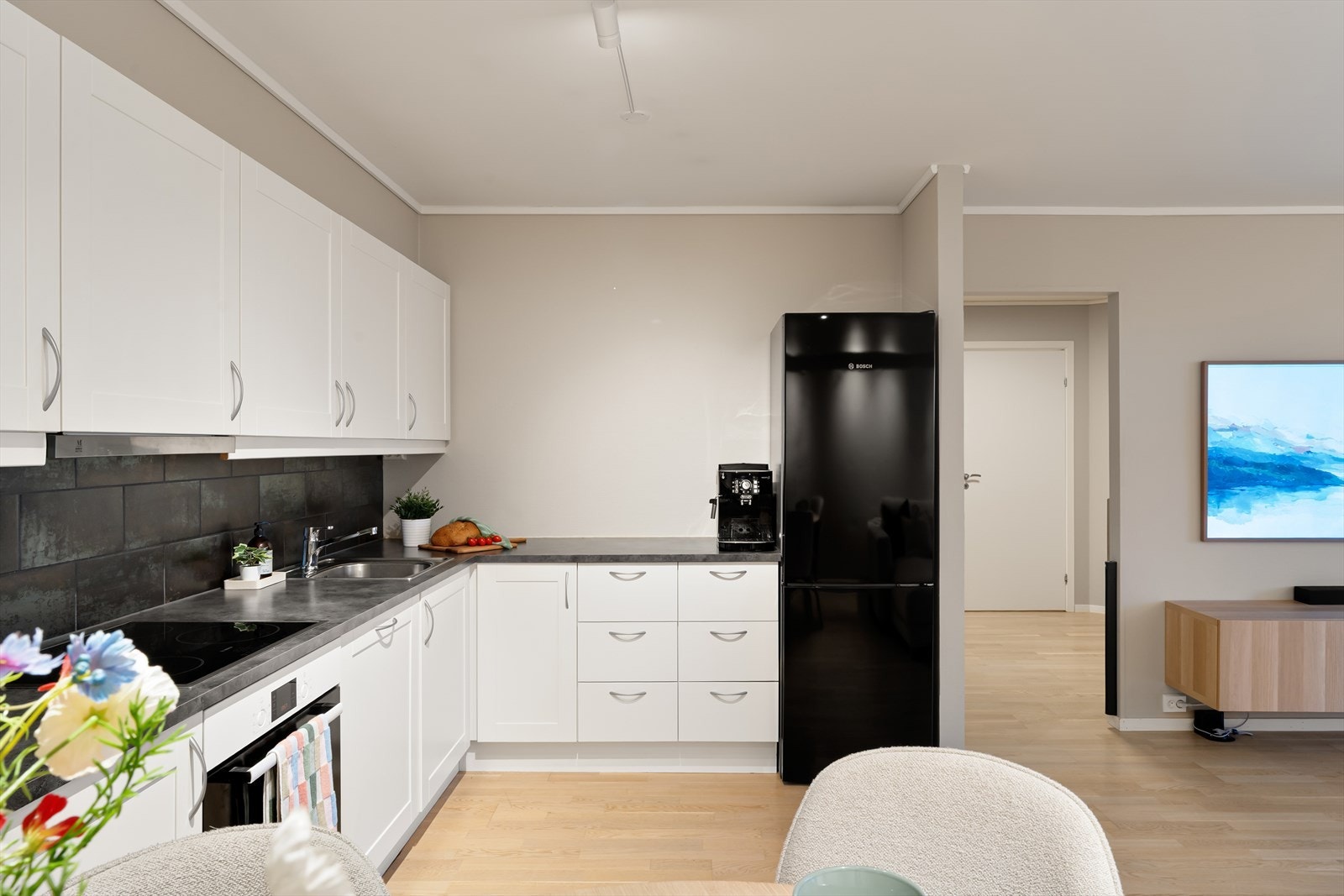 Lyst kjøkken med profilerte fronter. Gode arbeidsflater og rikelig med oppbevaringsplass. Galleribilde