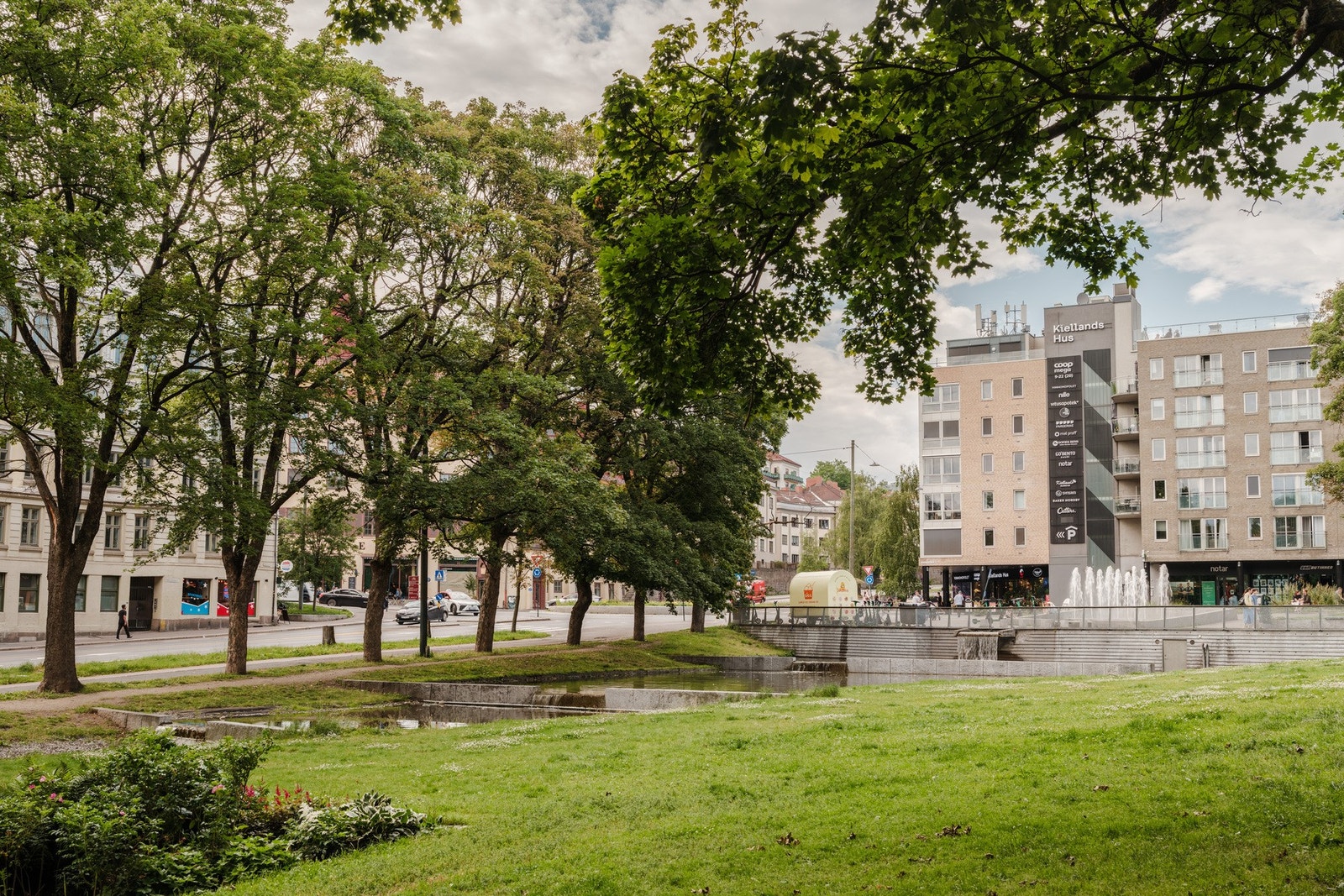 Frodig grøntanlegg, senter, og flere uteserveringer like utenfor boligen Galleribilde