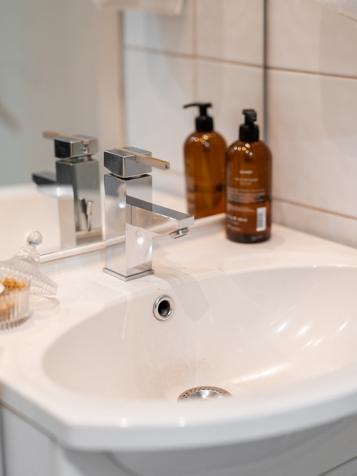 Baderomsinnredning med heldekkende servant med servantskap under og vegghengt speil for ytterligere oppbevaring Galleribilde