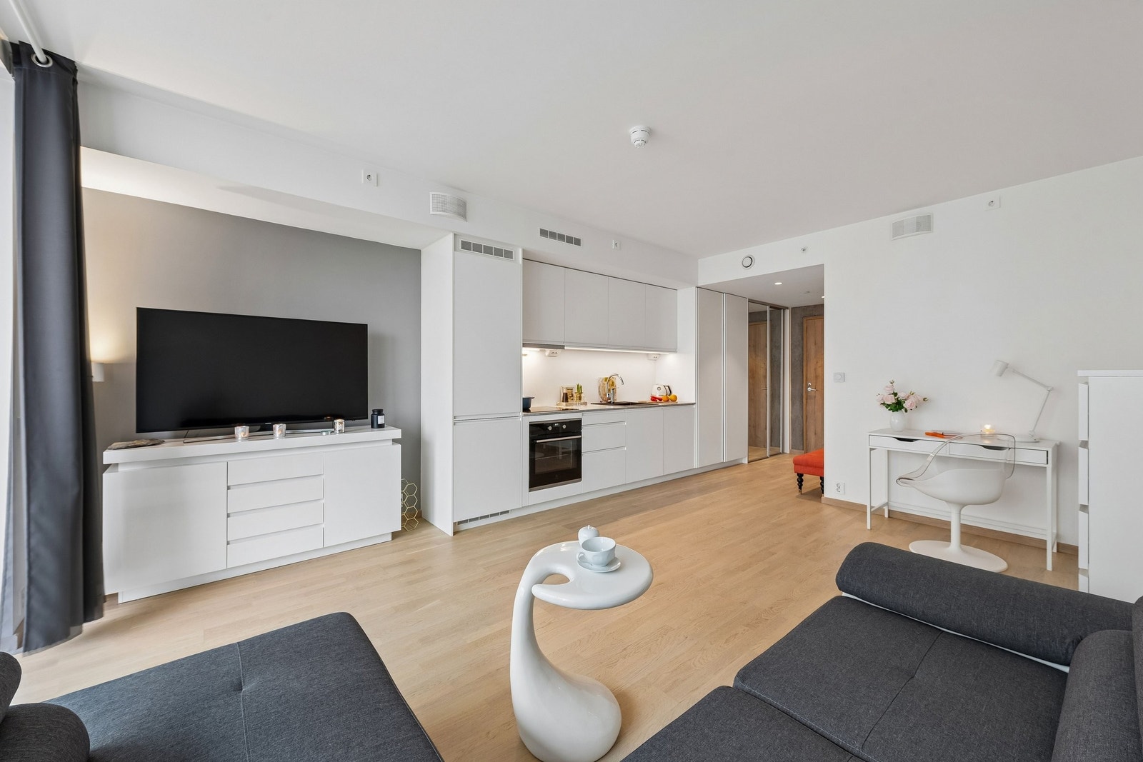 Den åpne løsningen mellom stue og kjøkken skapet den helhetlige utformingen og gir en god romfølelse. Galleribilde