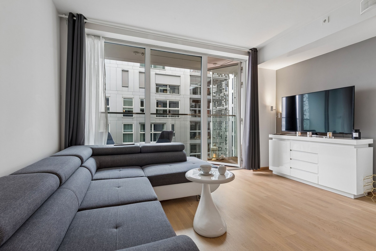 Den åpne løsningen mellom stue og kjøkken skapet en lys og luftig atmosfære Galleribilde