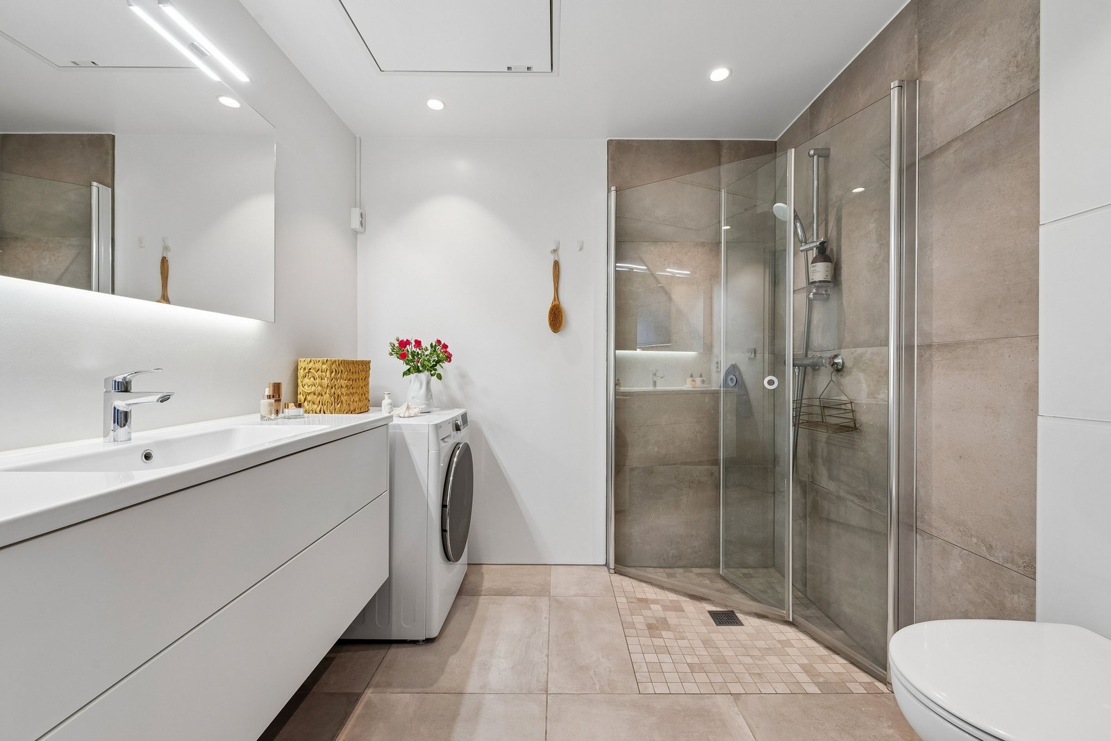 Badet er utstyrt med vegghengt toalett , dusjhjørne og servant med speilskap. Galleribilde