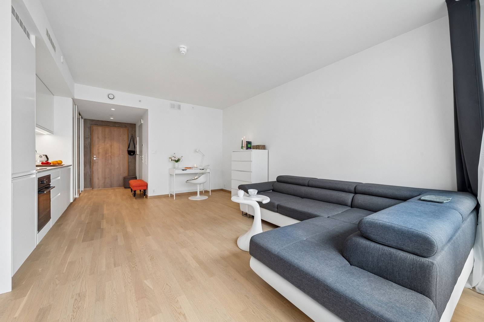 Den åpne løsningen mellom stue og kjøkken skapet en lys og luftig atmosfære Galleribilde