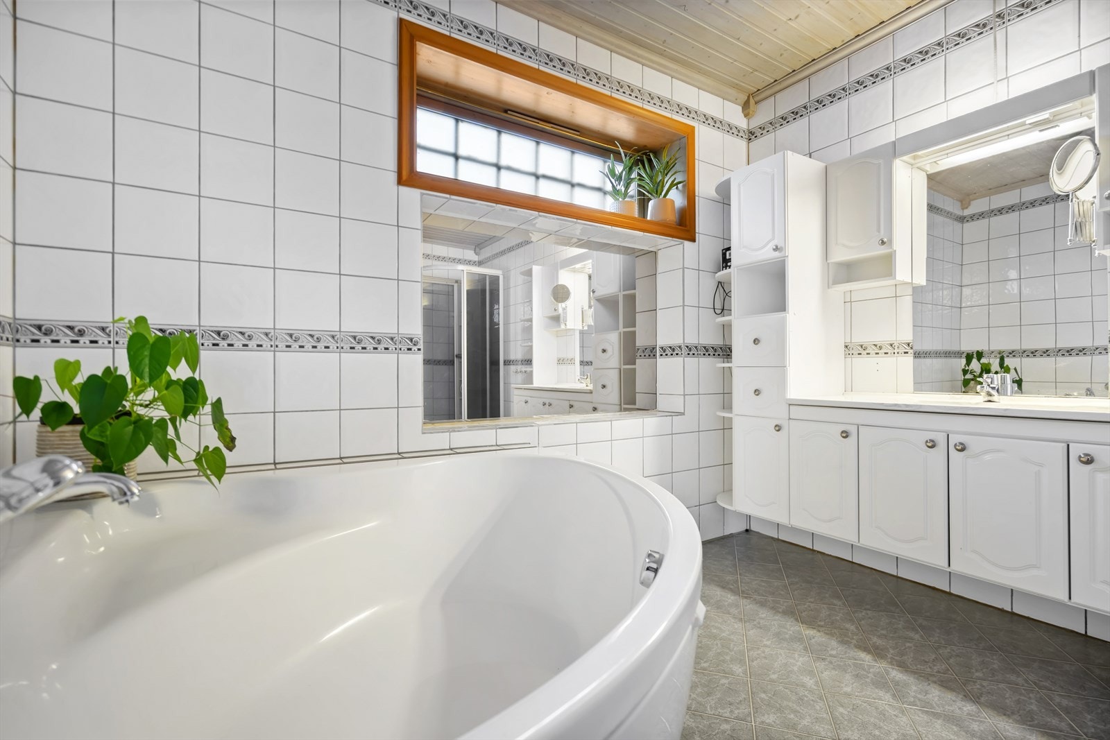 Flislagt bad med hjørnebadekar. Galleribilde