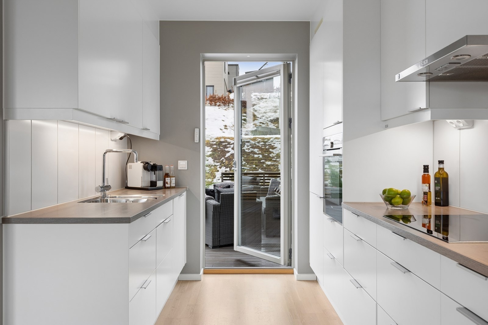 Slette fronter og splashboard mellom kjøkkenbenk og overskap er både stilrent såvel som praktisk for daglig renhold. Galleribilde