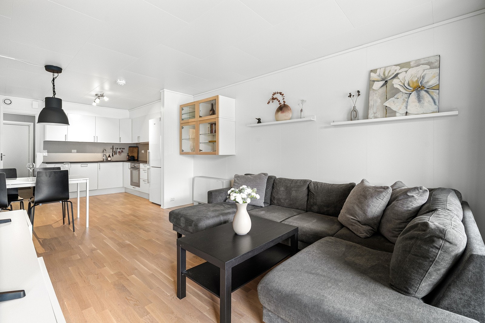 Åpen løsning mellom stue og kjøkken med god plass til både sofagruppe og spisebord. Galleribilde