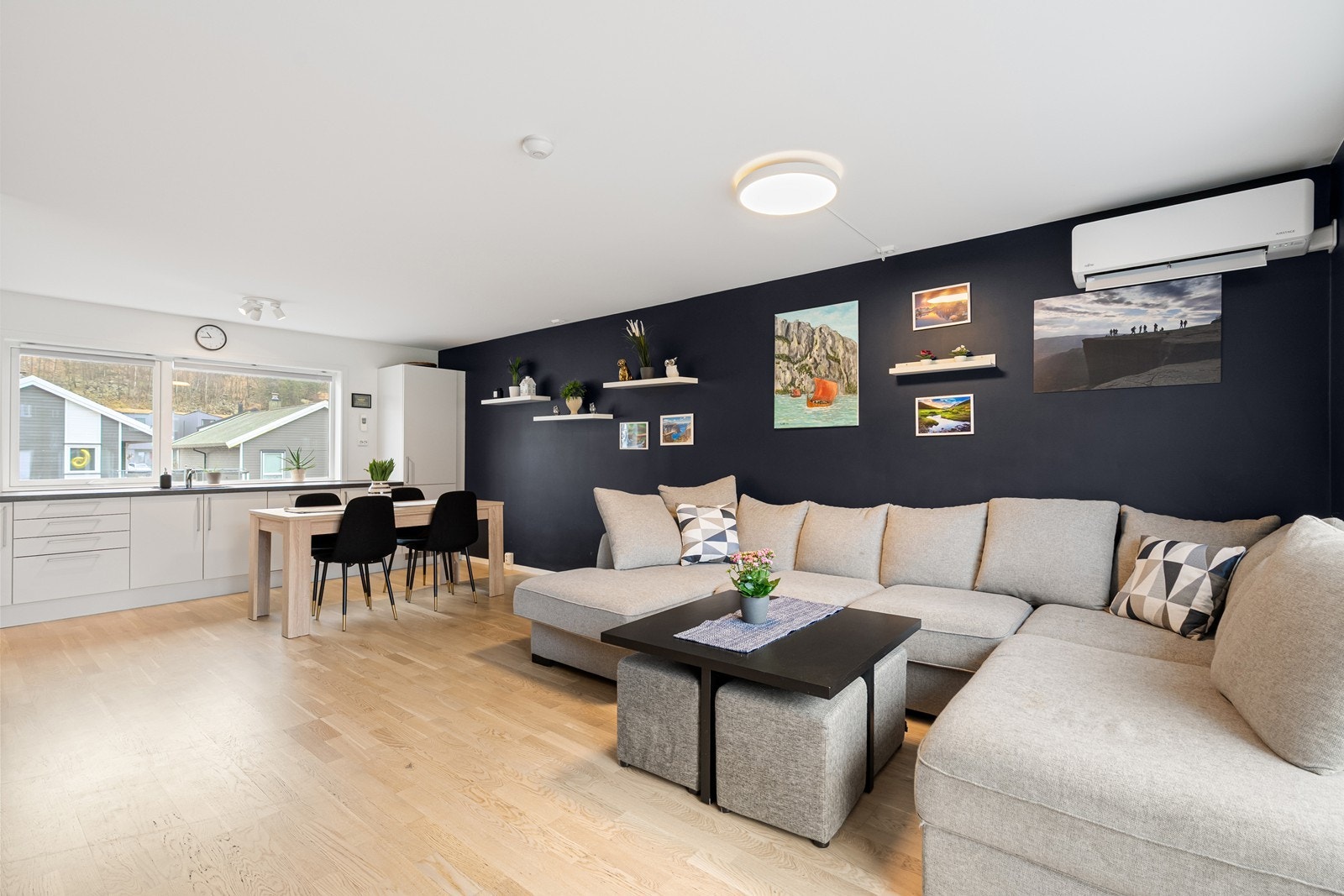 Plass til stor sofagruppe i stuen, med parkettgulv som gir et varmt uttrykk. Galleribilde