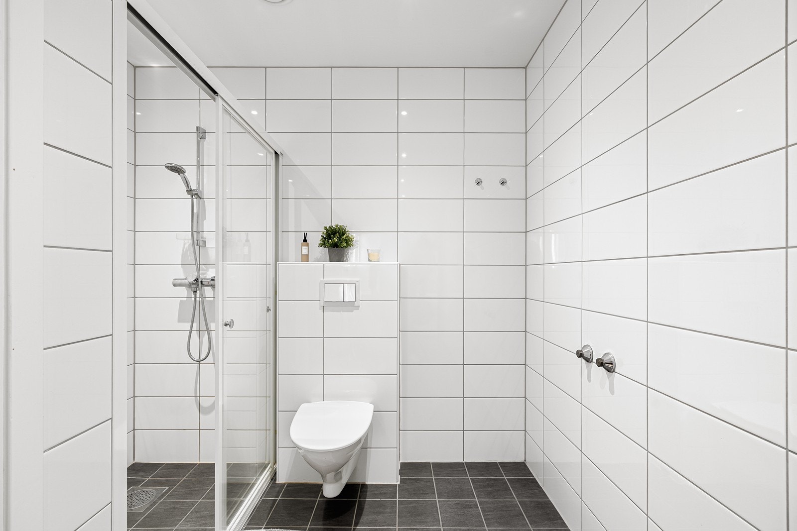 Vegghengt toalett og dusjhjørne gir en effektiv utnyttelse av baderommet. Galleribilde