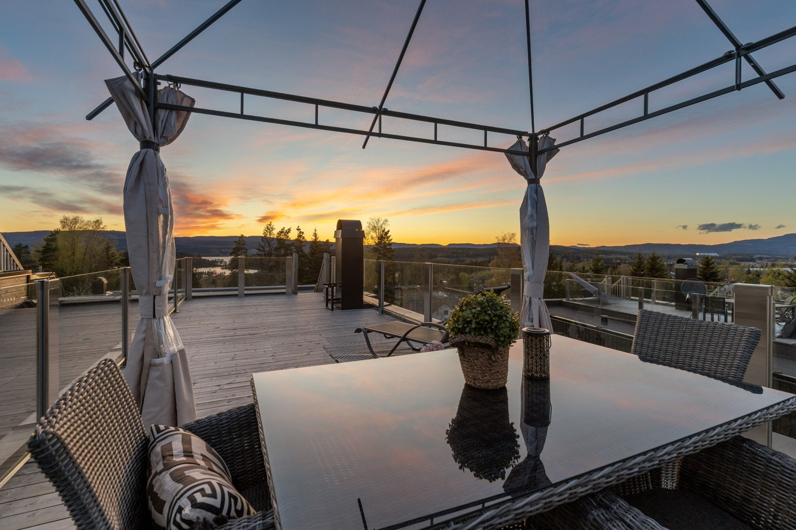 Takterrassen ligger høyt og fritt i terrenget med nydelig utsyn over nærområdet. Det er montert stilrent glassrekkverk. Galleribilde