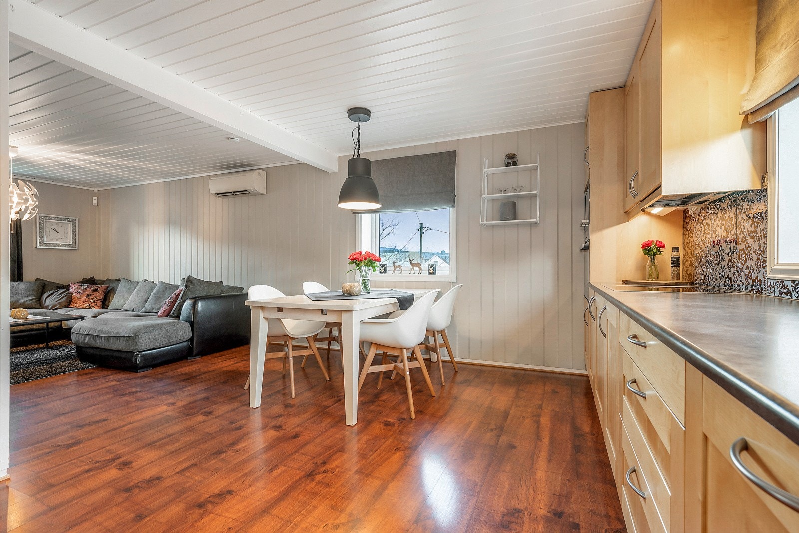 Boligen byr på en hyggelig stue med peisovn og åpen løsning mot kjøkkenet. Galleribilde