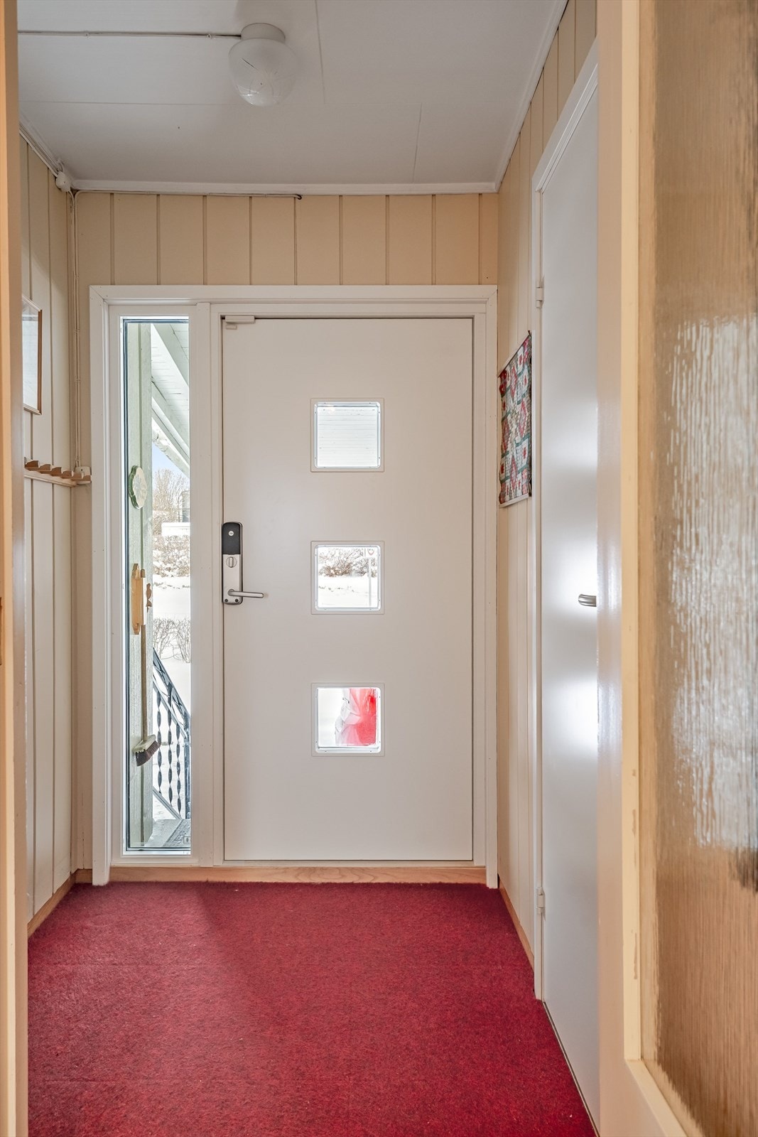 Du ønskes velkommen inn i en lys entré med plass til sko og oppheng av yttertøy. Ytterdør med 3 glassfelt fra 2019, sidefelt glass med 3-lags isolerglass og med montert kodelås. Galleribilde