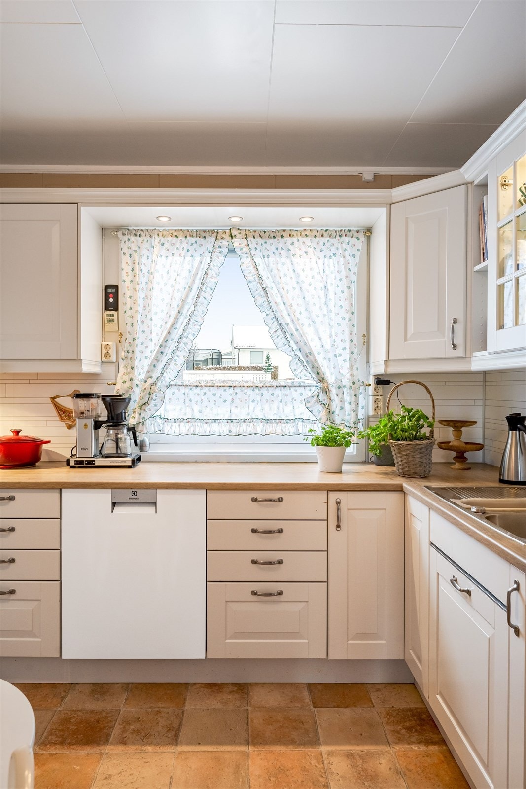 Innredningen har lyse profilerte fronter og laminert benkeplate med nedfelt oppvaskkum. Praktisk med flisimitasjonsplater i benkeryggen. Galleribilde