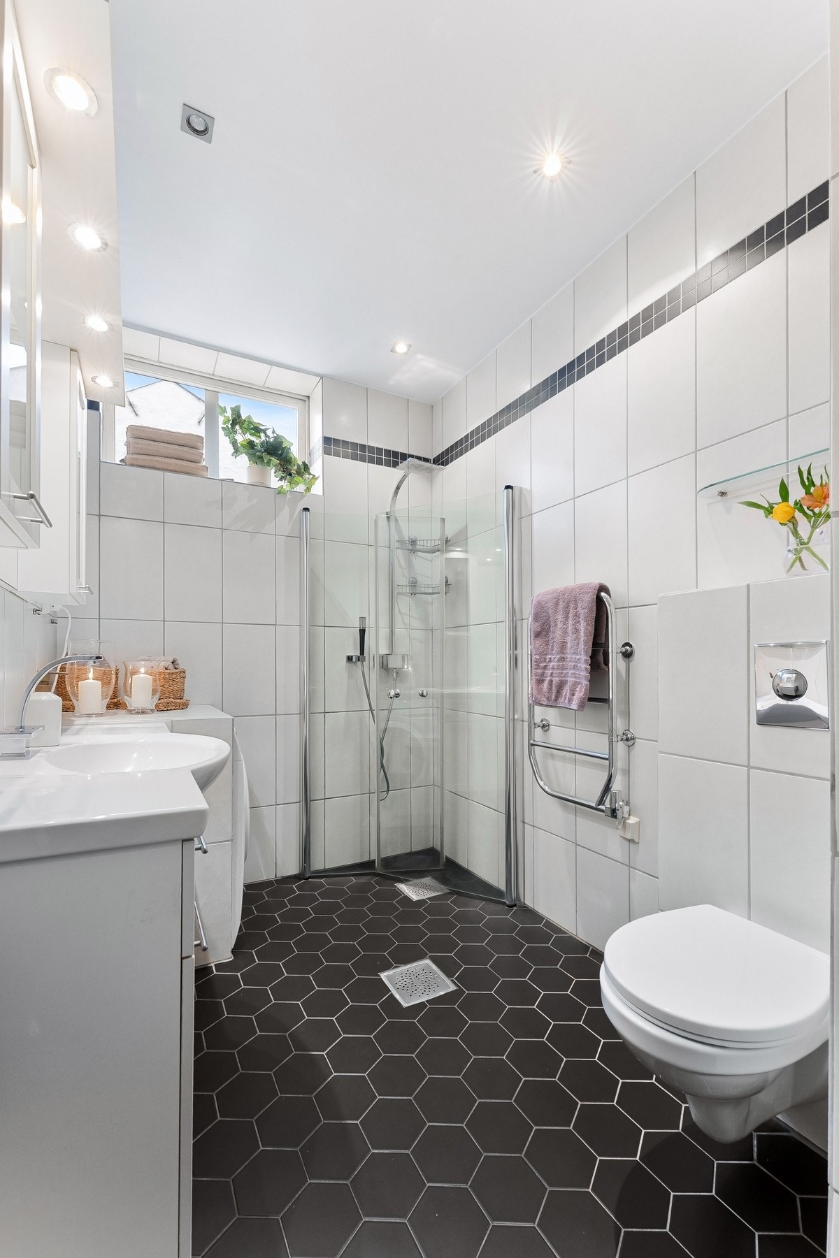 På badet er det også praktisk opplegg til vaskemaskin i stilig nisjeløsning. Det er også dusjhjørne med innfellbare glassdører, og rainfalldusj. Galleribilde