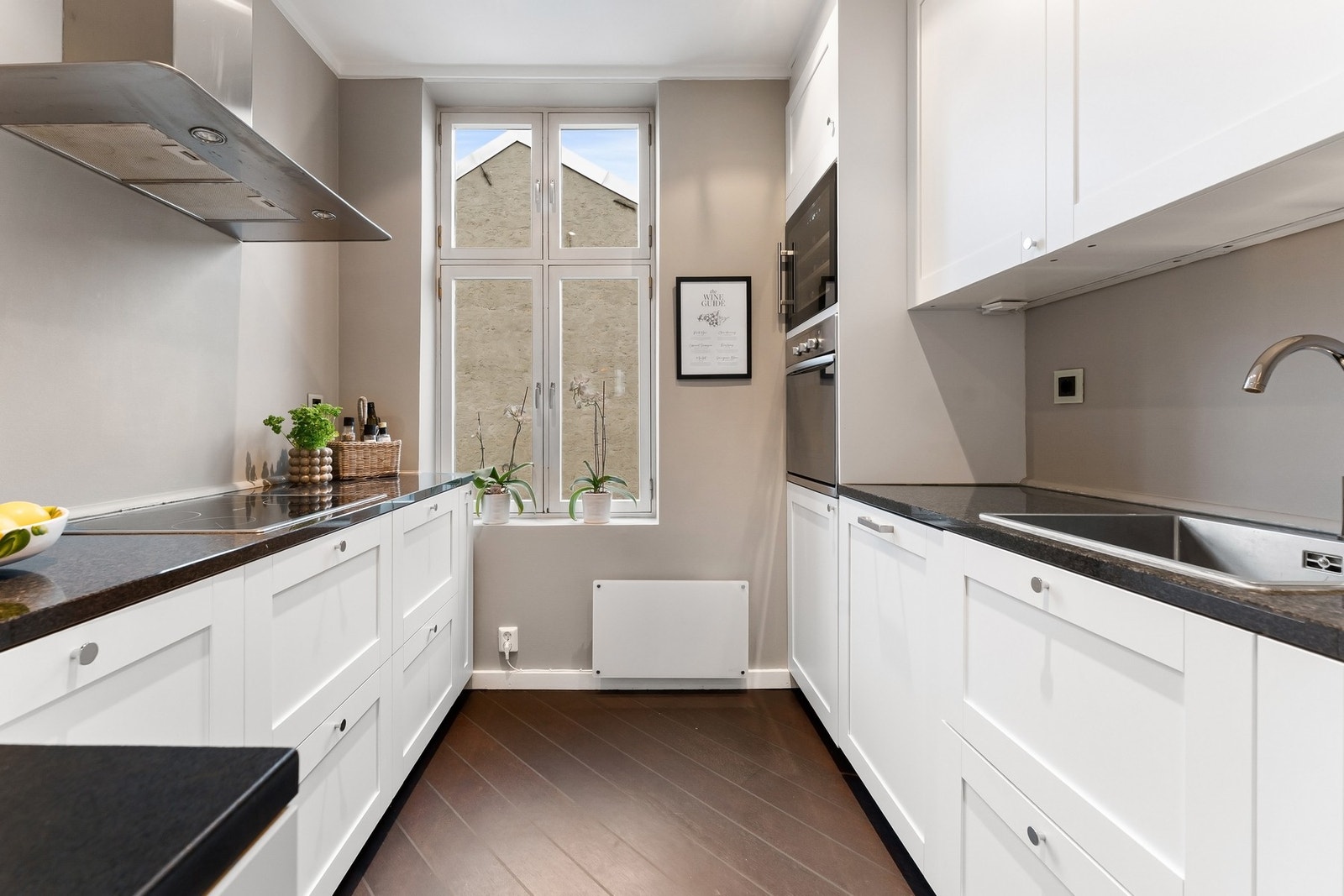 Leiligheten har et separat kjøkken med tidløs og lys innredning, og med et stort vindu som skaper en trivelig atmosfære. Galleribilde