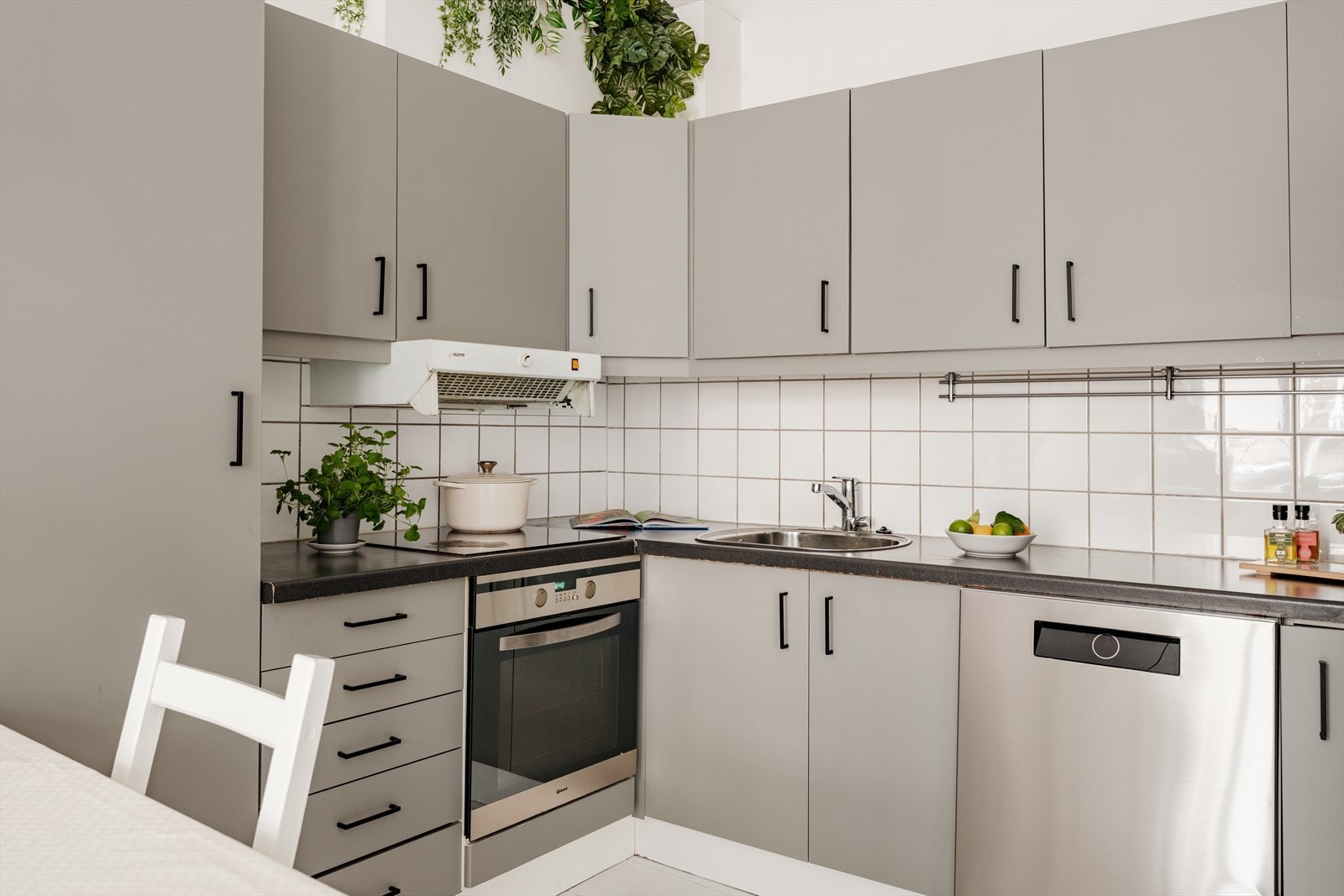 Flott innredning med slette fronter, fliser på bakvegg og laminert benkeplate Galleribilde