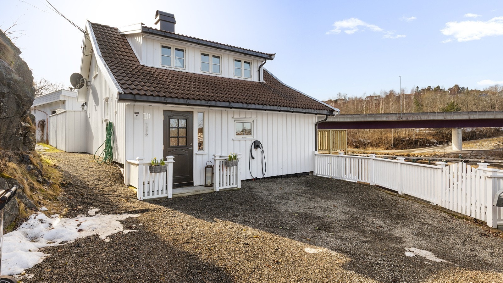 Utenfor er det biloppstillingsplass og montert elbil lader Galleribilde