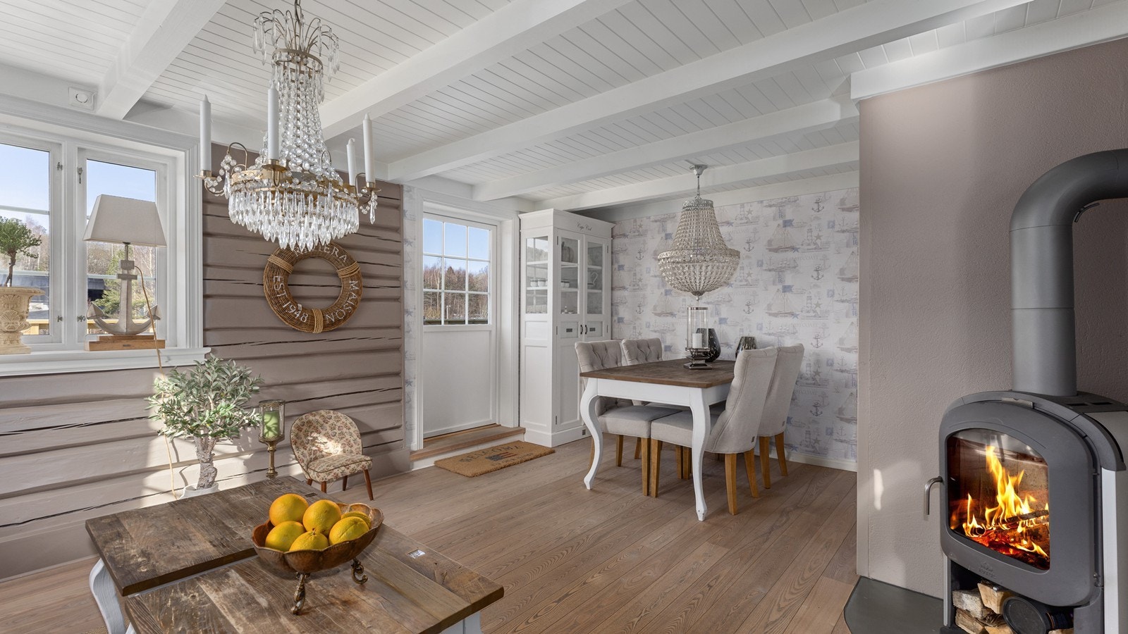 Fra kjøkkenet er det adkomst til hyggelig stue med eksponert laft og peisovn Galleribilde