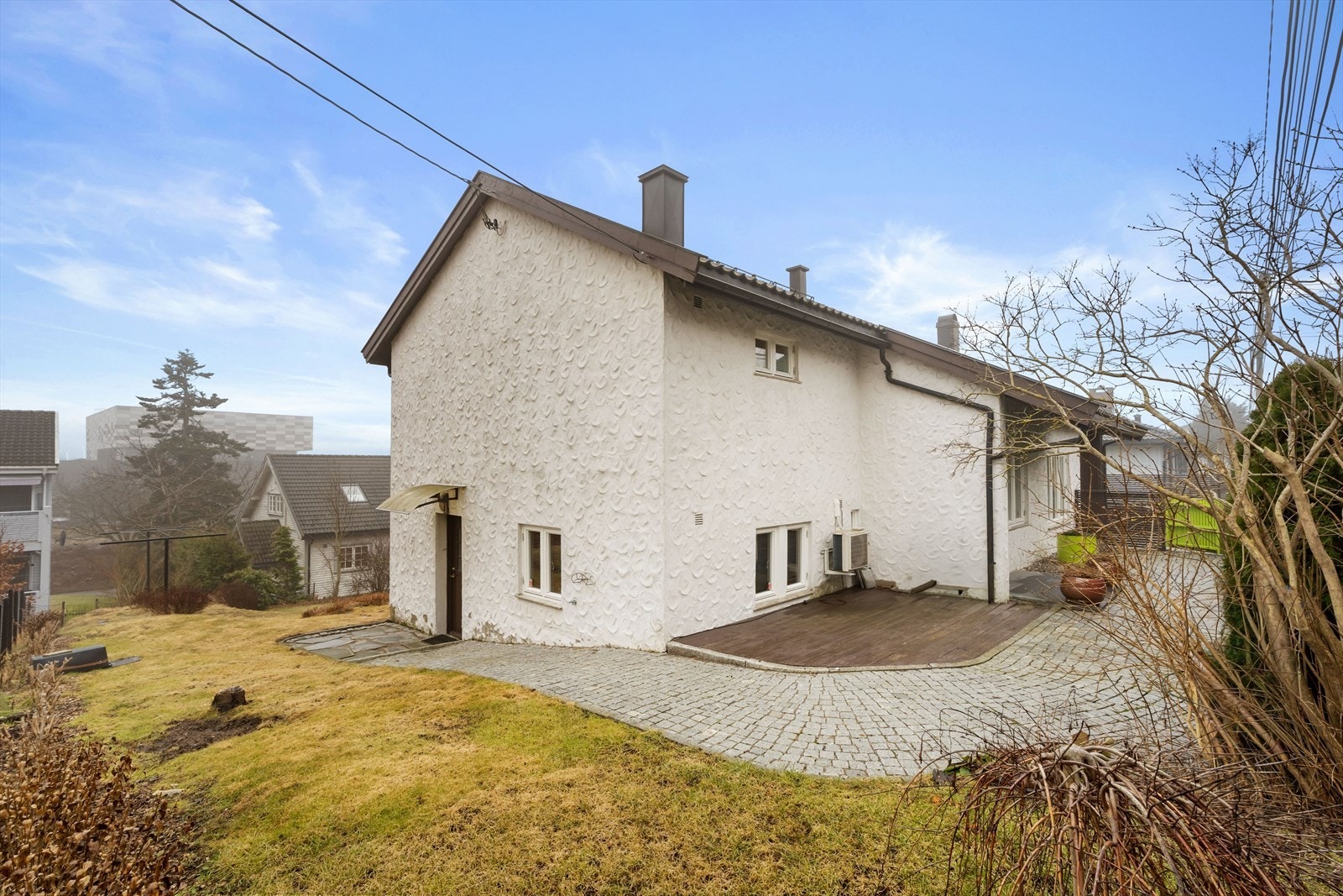 Eiendommen har en sørvendt, skrånende tomt som er opparbeidet med gressplen, busker og frukttrær. Galleribilde