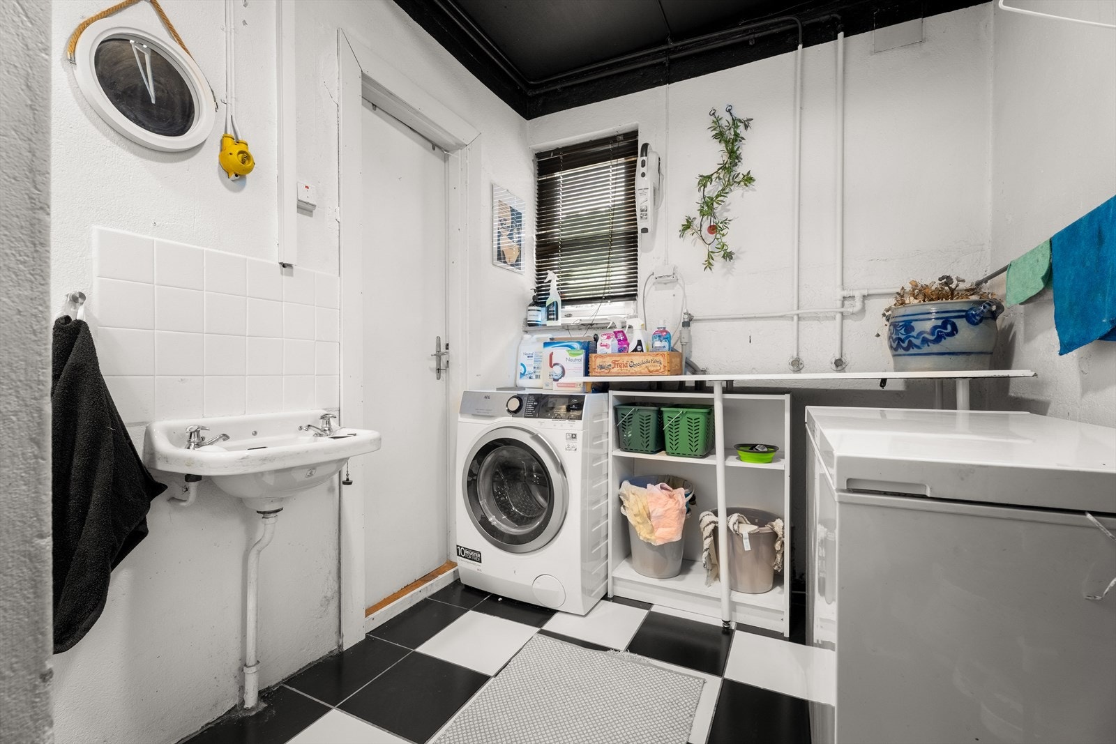 Vaskerommet har flislagt gulv fra 2006, opplegg for vaskemaskin og servant. Galleribilde