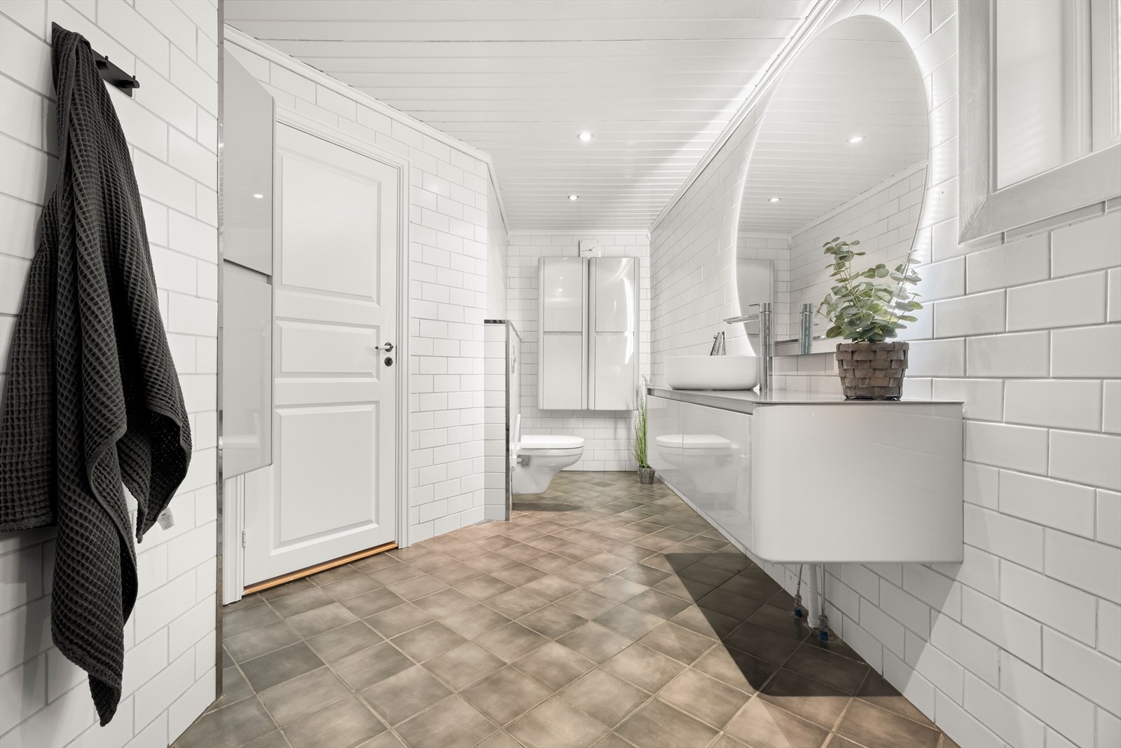 Badet er utstyrt med vegghengt toalett og innebygde oppbevaringsskap. Galleribilde