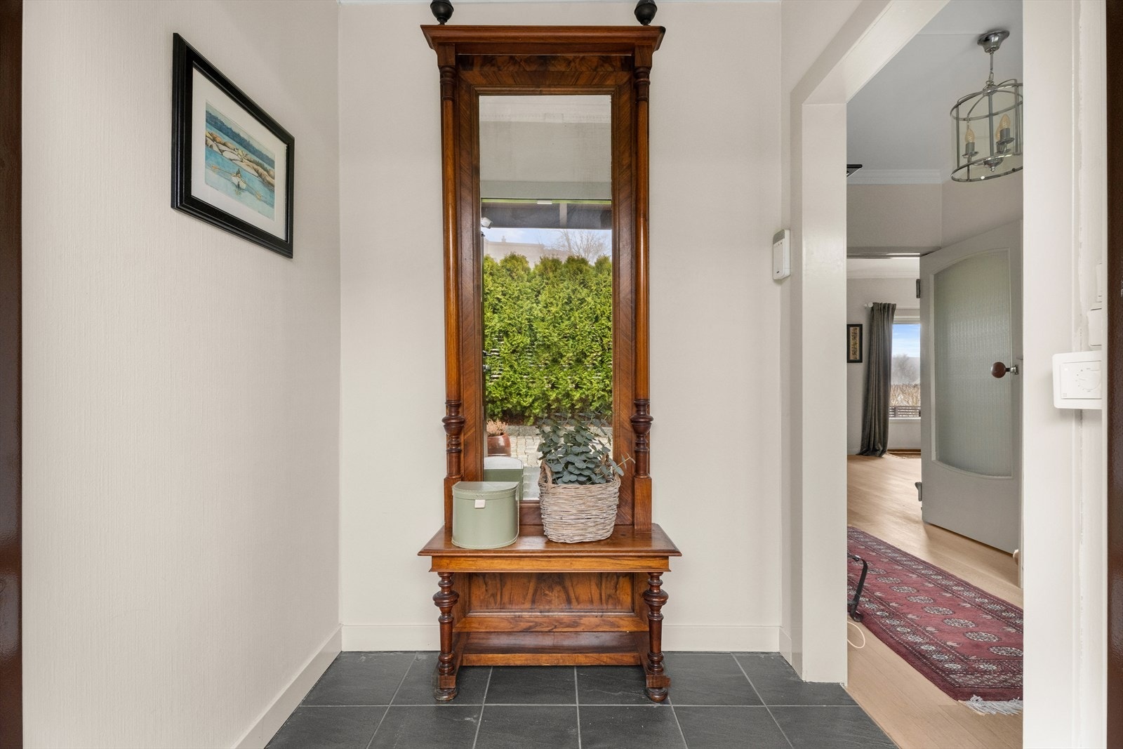 Vindfanget har praktiske fliser på gulvet og leder videre inn i boligens gang. Galleribilde