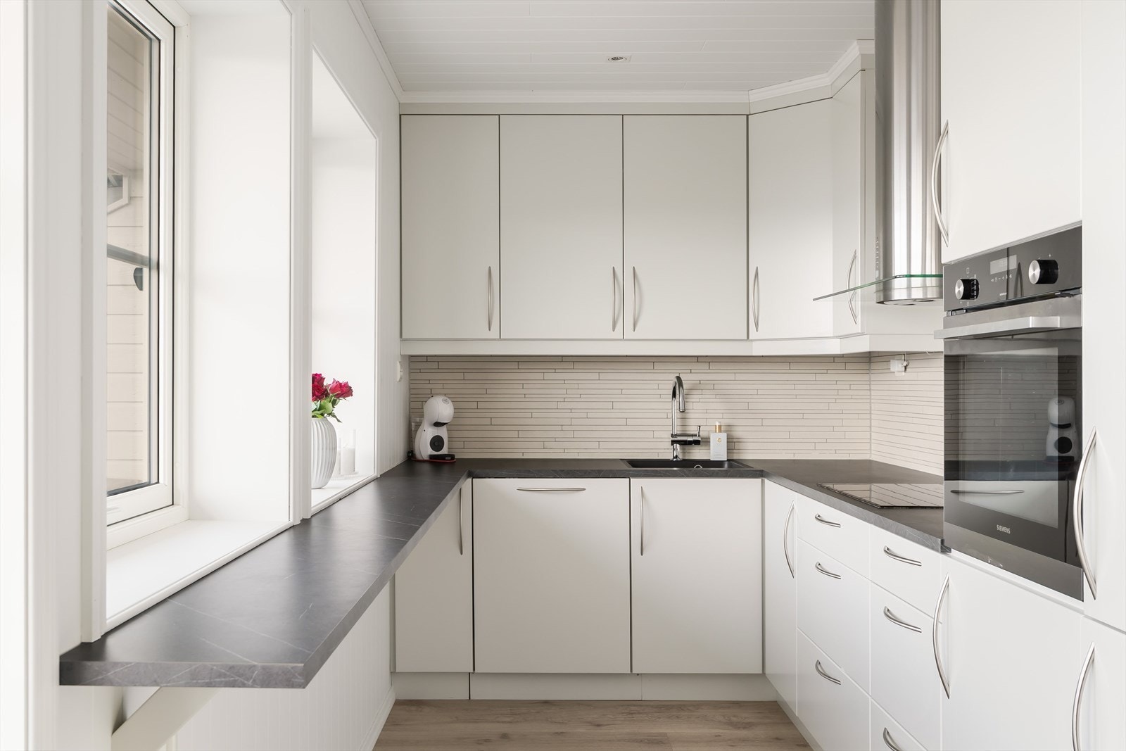 Velutstyrt kjøkken med kjøl/fryseskap, oppvaskmaskin, platetopp, stekeovn og kjøkkenventilator med avtrekk. Galleribilde