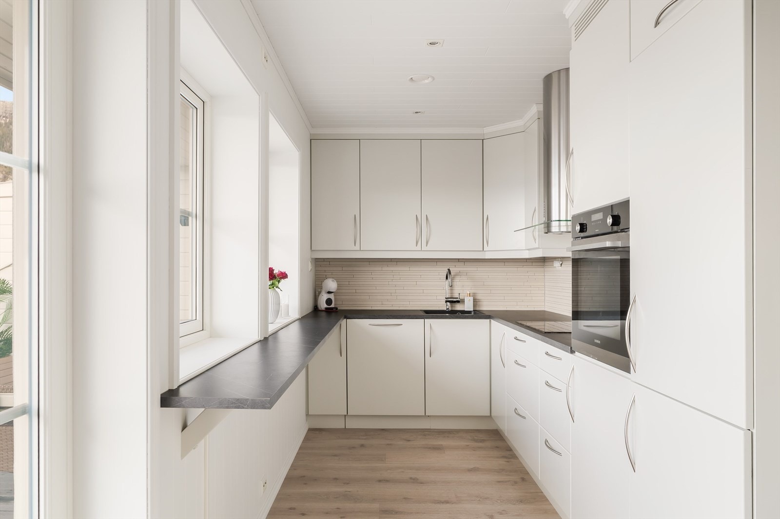 Pent og moderne kjøkken glatte fronter og benkeplaten er av laminat. Vurdert til TG1 av takstmann. Galleribilde