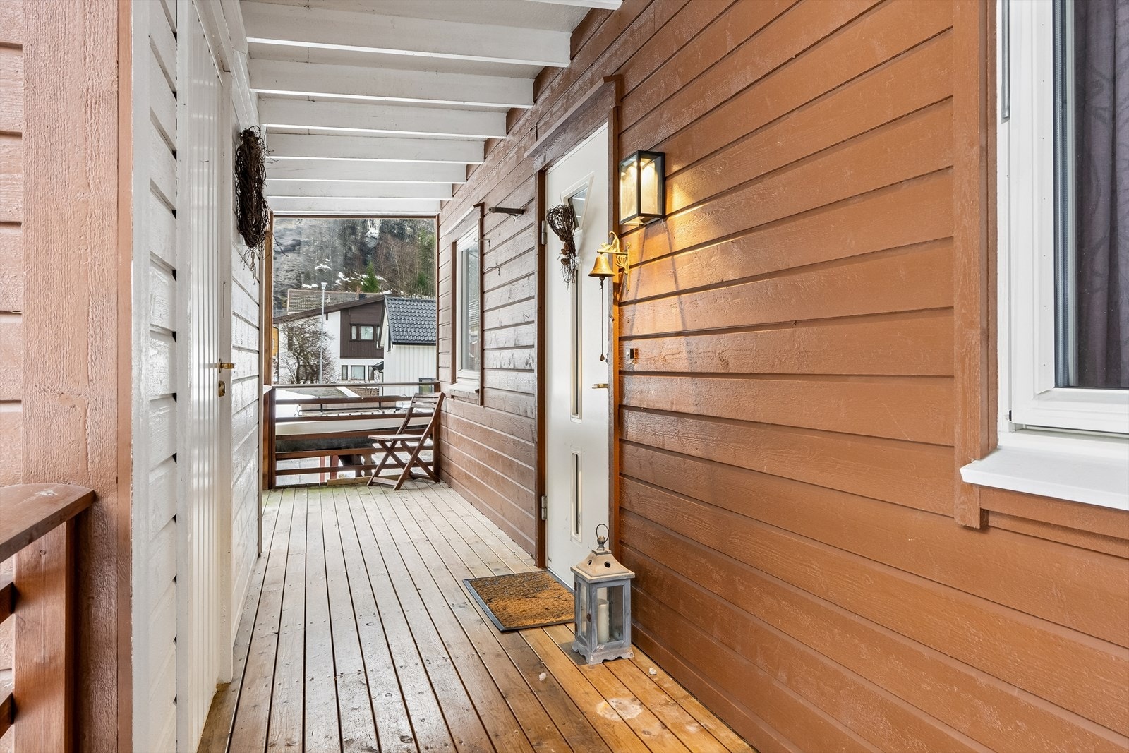 Overbygd inngangsparti og dør (venstre) inn til bod. Galleribilde