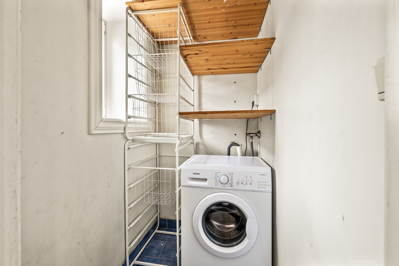 Praktisk, separat vaskerom med flislagt gulv og opplegg for vaskemaskin. Galleribilde