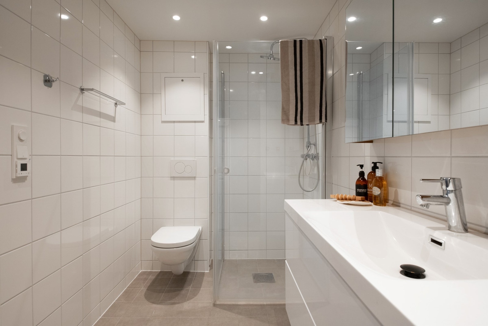 Badet er innredet med vegghengt toalett, romslig servantinnredning med god oppbevaringsplass og speilskap. Dusjsonen er avgrenset med glassvegger og har moderne armatur. B Galleribilde