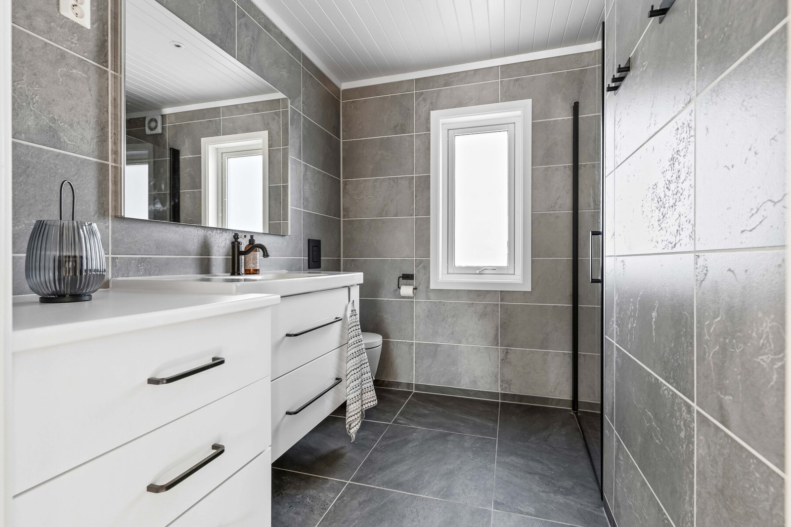 Smakfullt hovedbad, totalrehabilitert i regi av fagfolk i 2019. Badet har fliser med gulvvarme, moderne baderomsplater på vegg, servantmøblement i helstøpt plate, speil og vegghengt toalett. Galleribilde