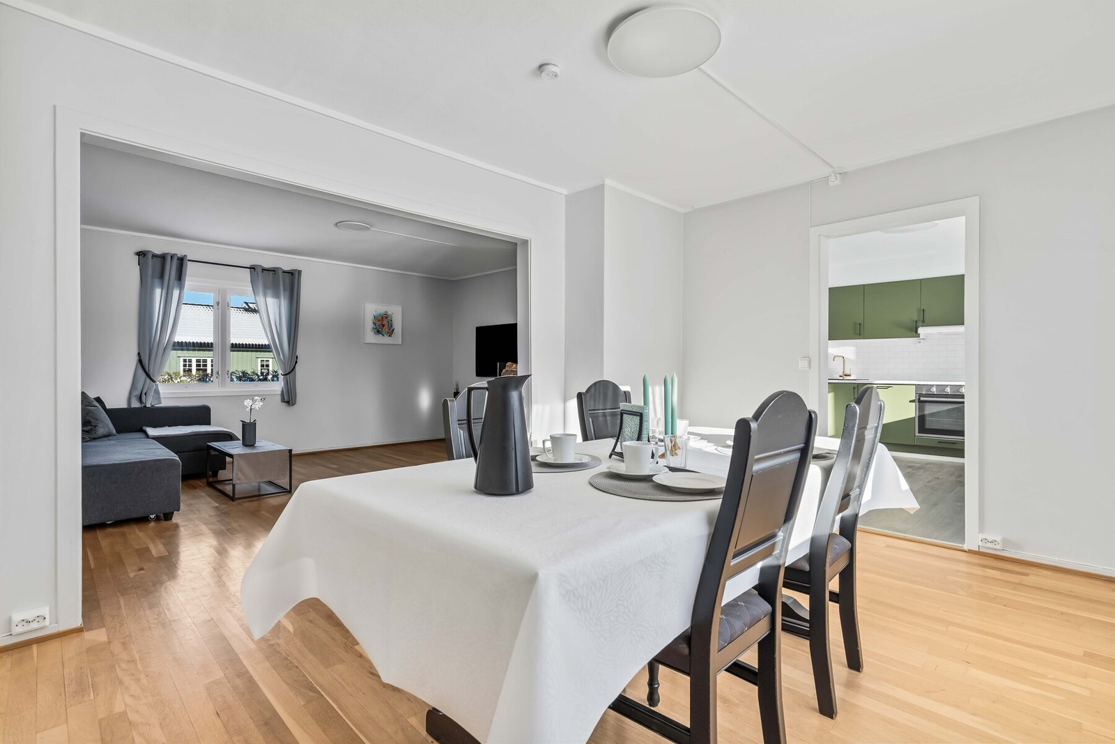 Spisestuen i forkant av kjøkkenet innbyr til hyggelige måltider med familie og venner, med flott lysinnslipp fra store vindusflater. Galleribilde