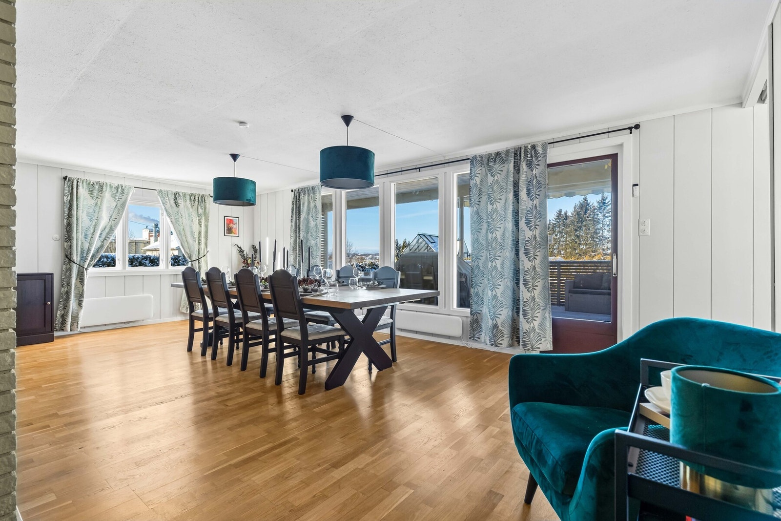 Rommet har lysmalte veggflater, parkett på gulv og store vindusflater i flere himmelretninger som gir flott utsyn over hagen. Galleribilde