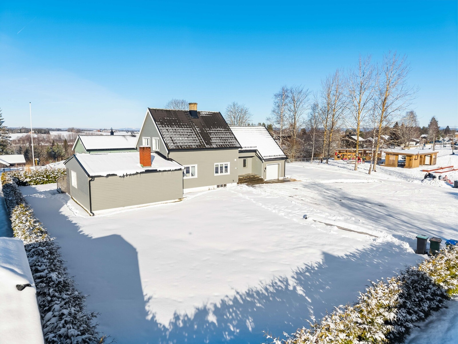 Eiendommen er delvis omkranset av en vintergrønn hekk som gir skjerming og privatliv. Galleribilde