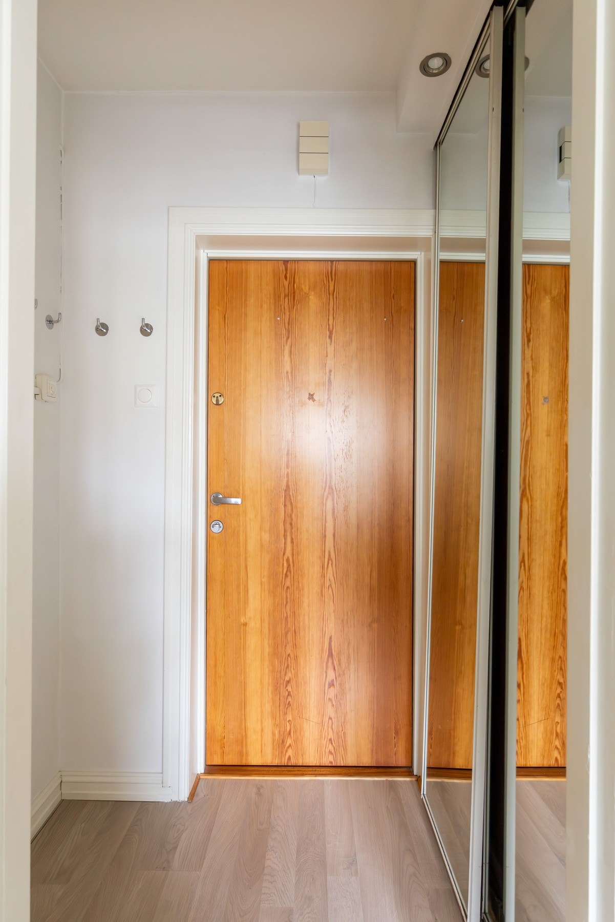 Entréen har et lyst og oversiktlig uttrykk, med garderobeløsning i skyvedører med speilfronter som gir god oppbevaringsplass. Galleribilde