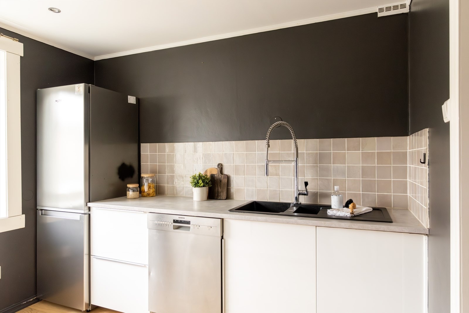 Kjøkkeninnredningen består av hvite, glatte fronter og benkeplate av laminat med nedfelt vask- og skyllekum. Galleribilde