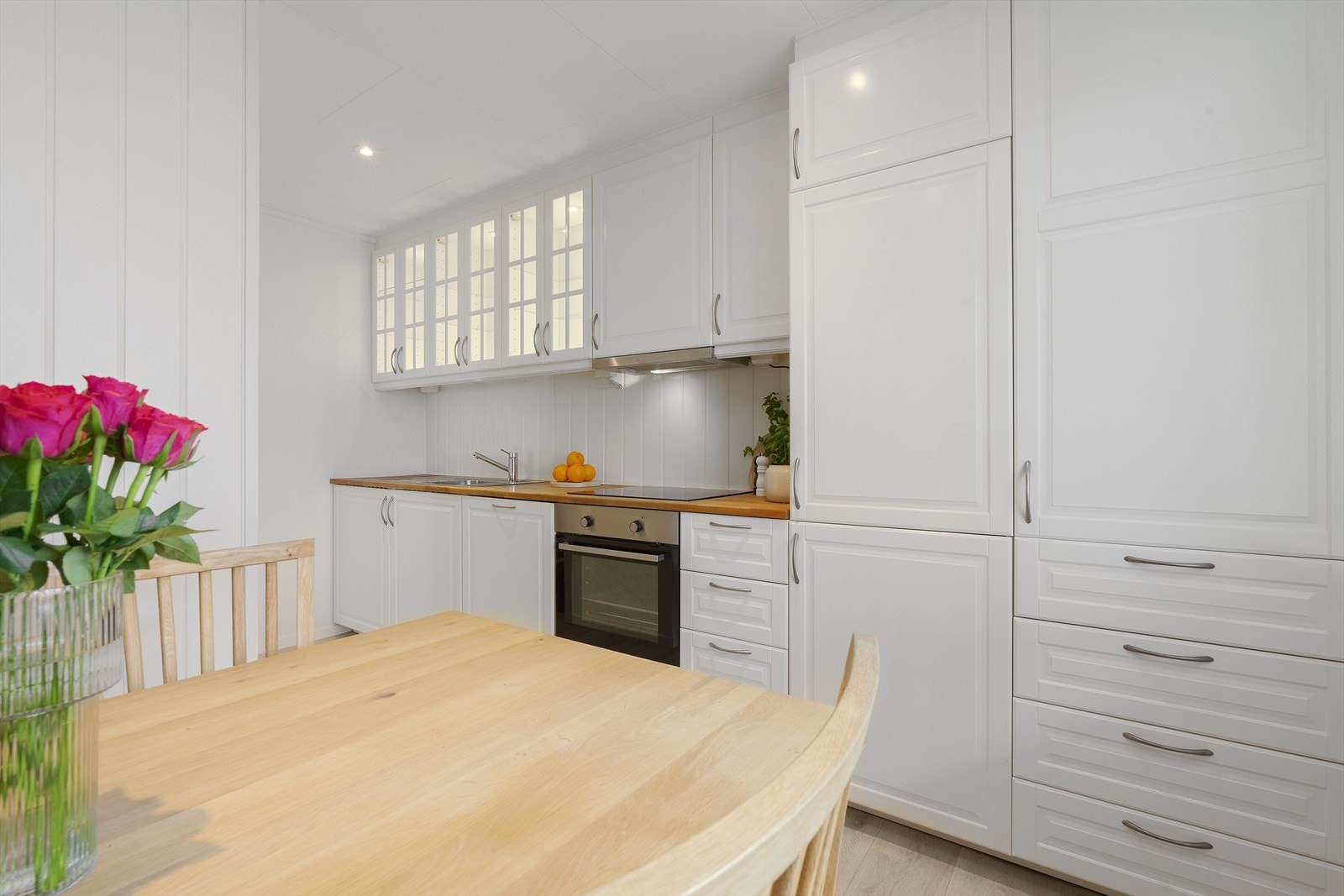 Trivelig og moderne kjøkken med hvite fronter og integrerte hvitevarer. Galleribilde