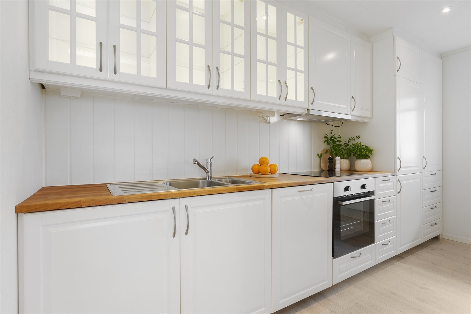 Benkeplate i tre gir en varm kontrast til de hvite skapene. Galleribilde