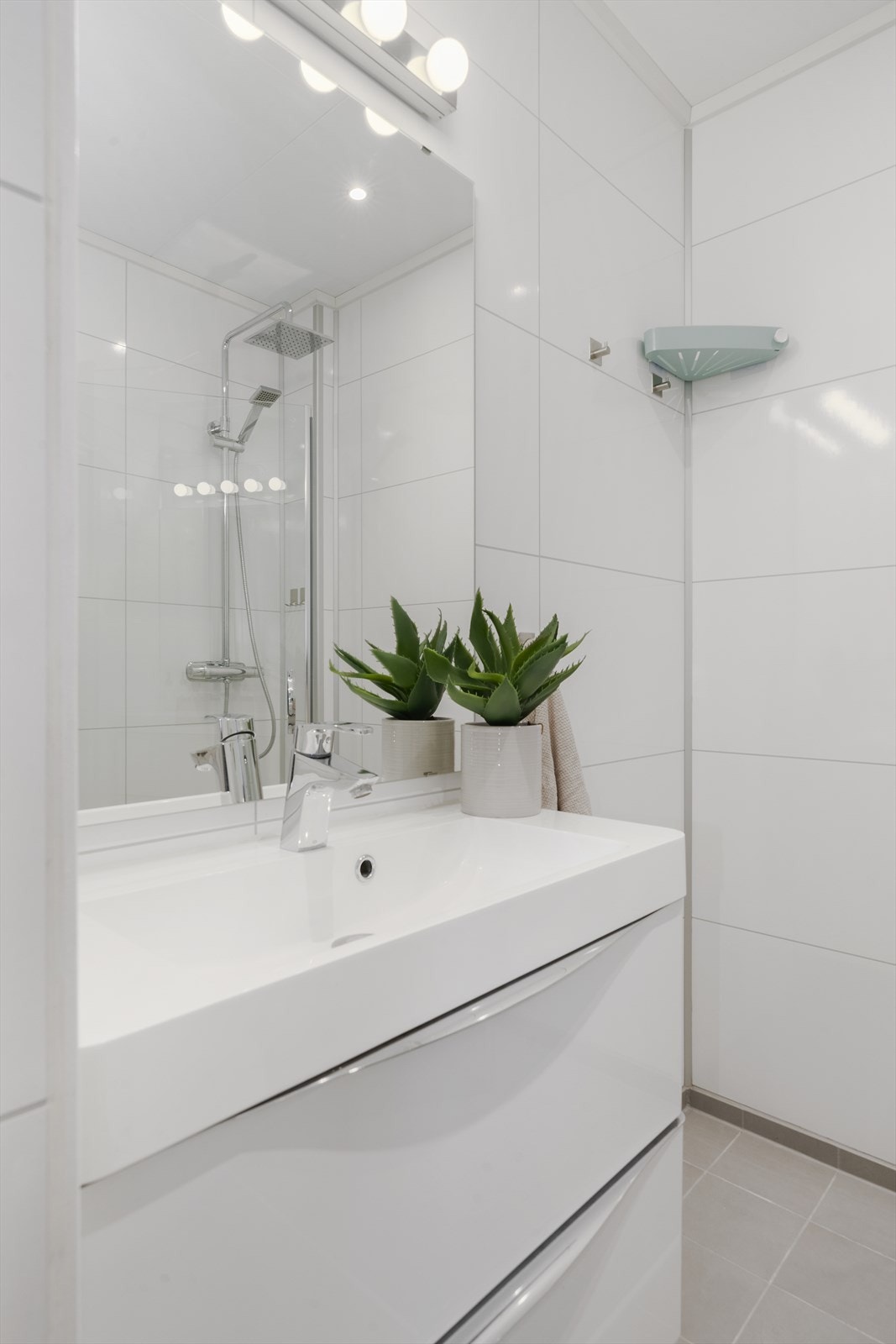 Servant med skuffeløsning gir god oppbevaringsplass, og speilet har integrert belysning for optimal lyssetting. Galleribilde