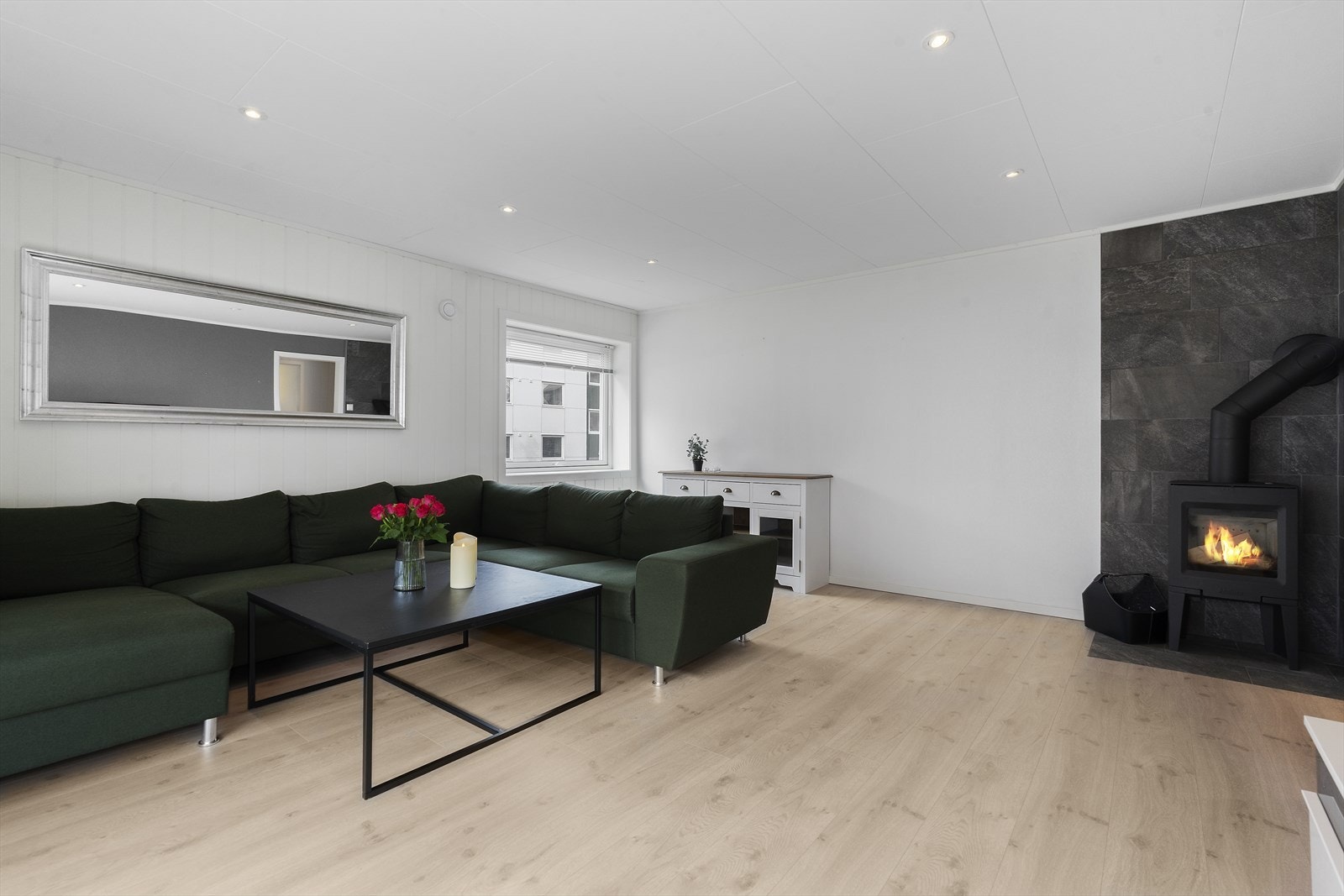 Vedovn montert på stue, som bidrar med jevn varme og en hyggelig atmosfære. Galleribilde