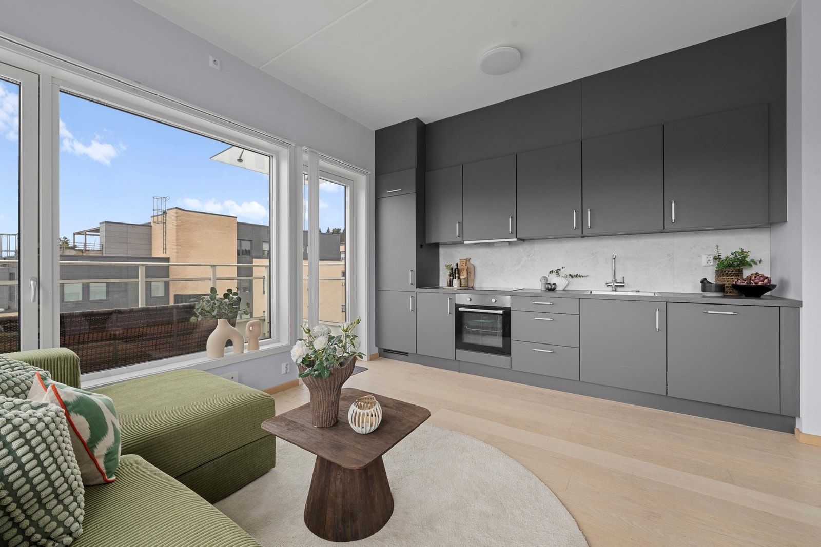 Kjøkkenet er innredet med glatt, laminert kjøkkeninnredning og laminert benkeplate, som gir et stilrent og tidløst uttrykk Galleribilde