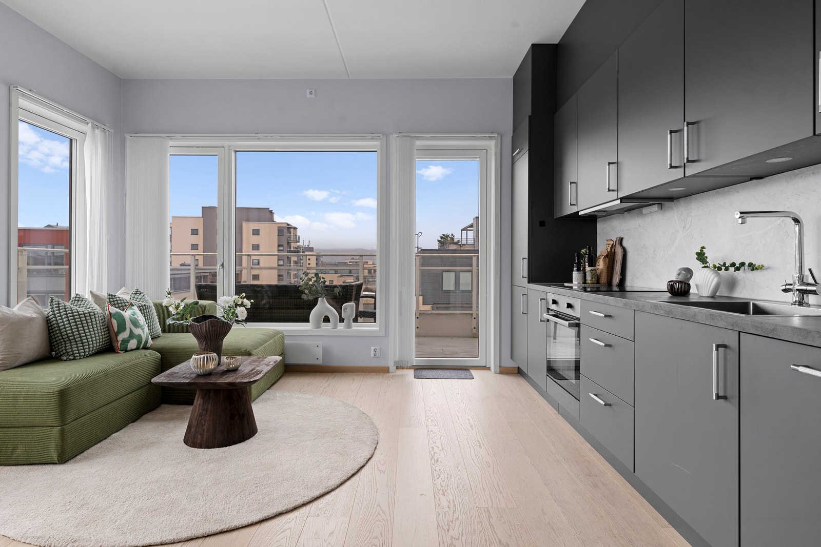 Moderne kjøkken fra 2021 med åpen og sosial løsning mot stuen, som gir en luftig romfølelse og gode soner for både matlaging og samvær Galleribilde