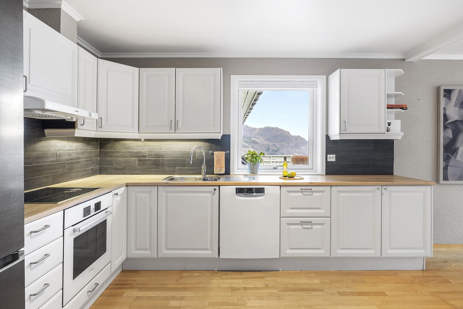 Kjøkkenet er klassisk og tidlaust, med kvite, profilerte frontar og benkeplate i laminat med trestruktur. Galleribilde