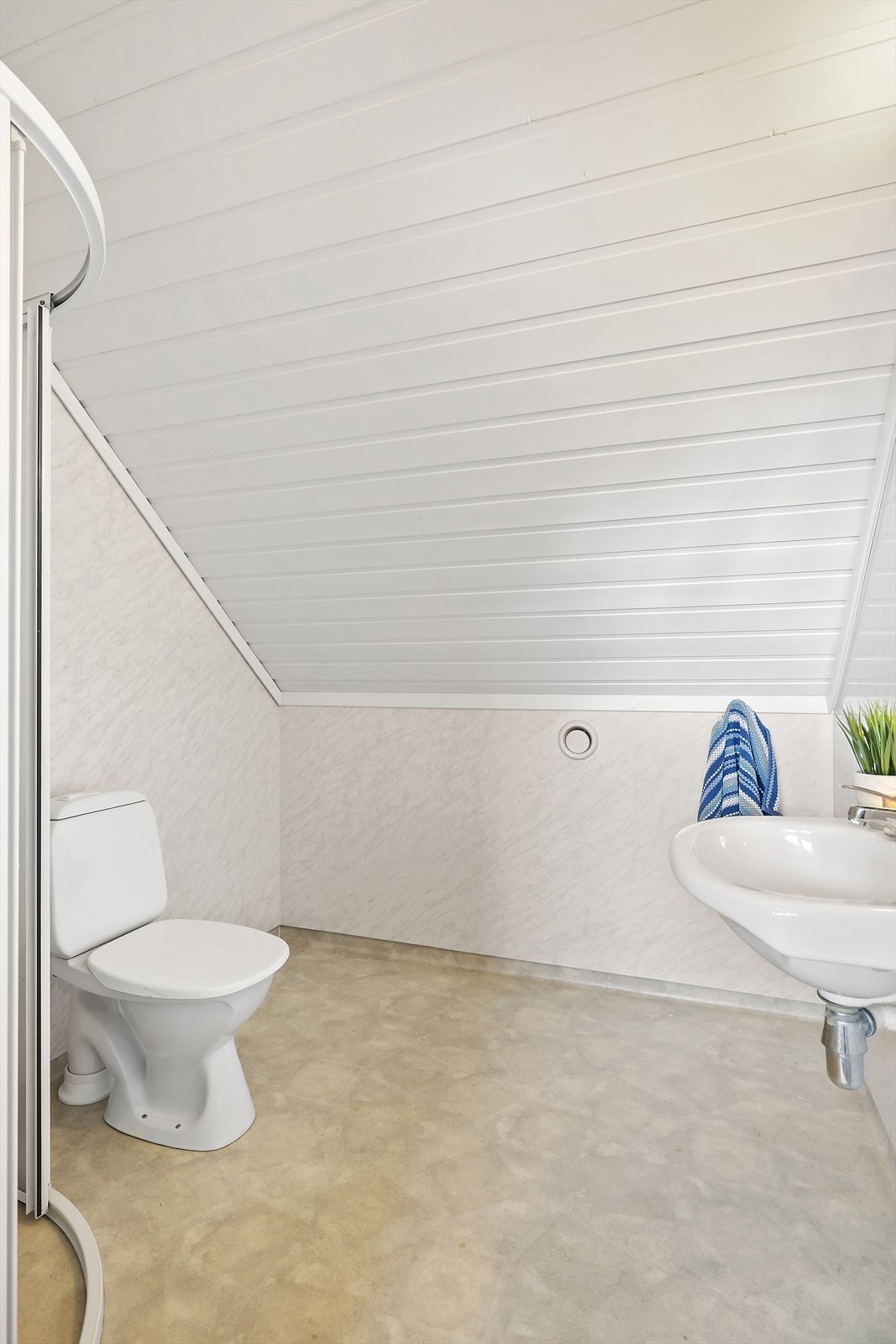 Badet i 2.etg er innreiia med dusj på vegg med sokkellist, wc og servant. Galleribilde