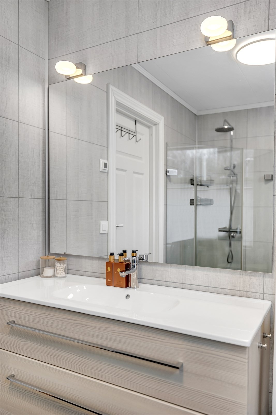 Badet har en stor servant med rikelig oppbevaring i underkant, og speil med lys. Galleribilde